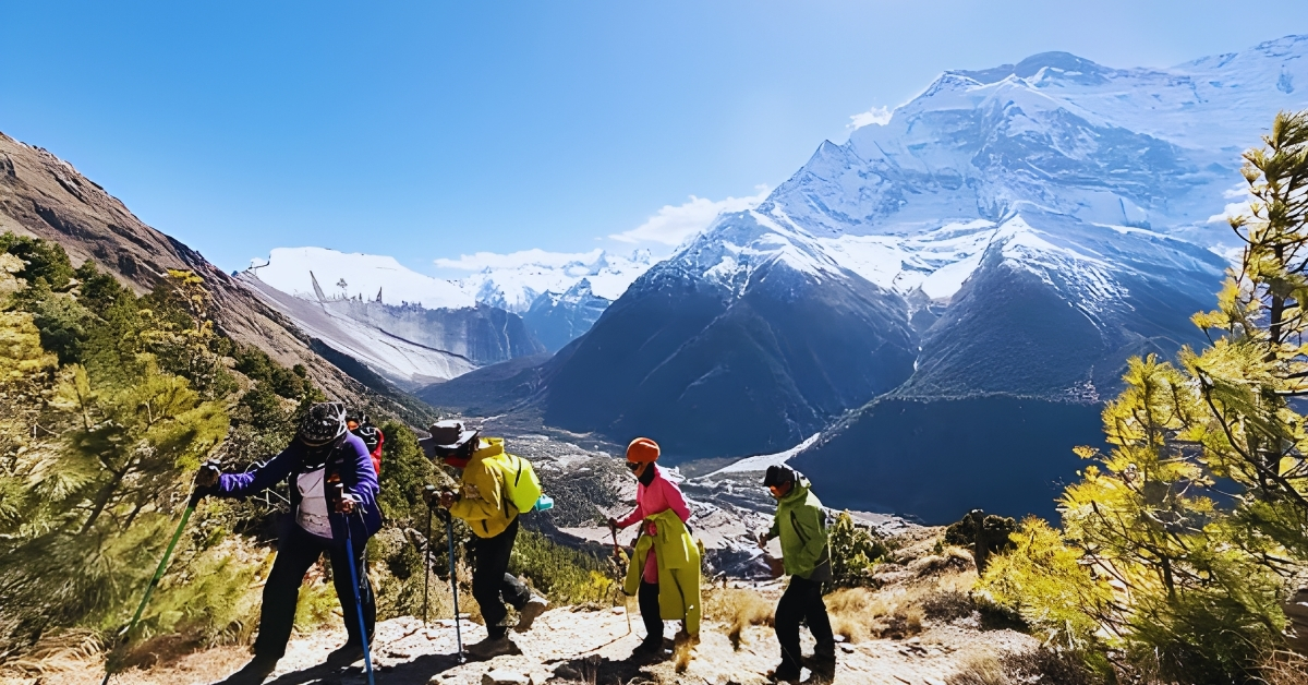 নেপালের হিমালয় পর্বতে ট্রেকিং করছেন ভ্রমণকারীরা, পেছনে তুষারঢাকা পাহাড়